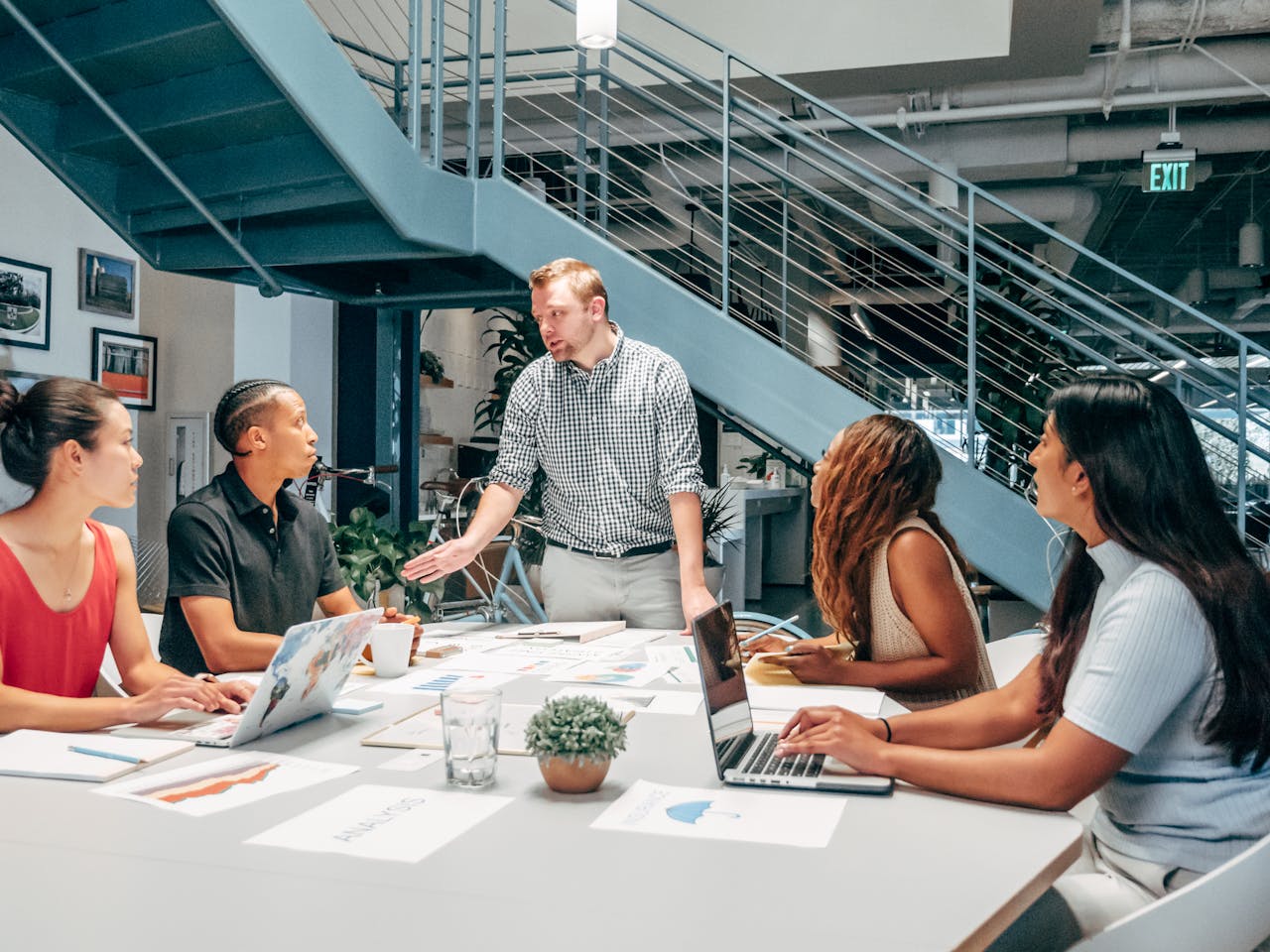 A diverse group of businesspeople brainstorming around a table in a modern workspace.